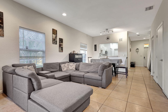 living area with light tile patterned floors, visible vents, and recessed lighting