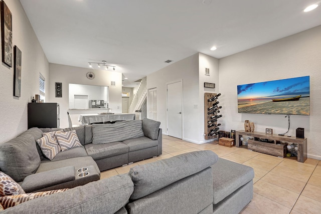 living room with light tile patterned floors, baseboards, recessed lighting, and track lighting