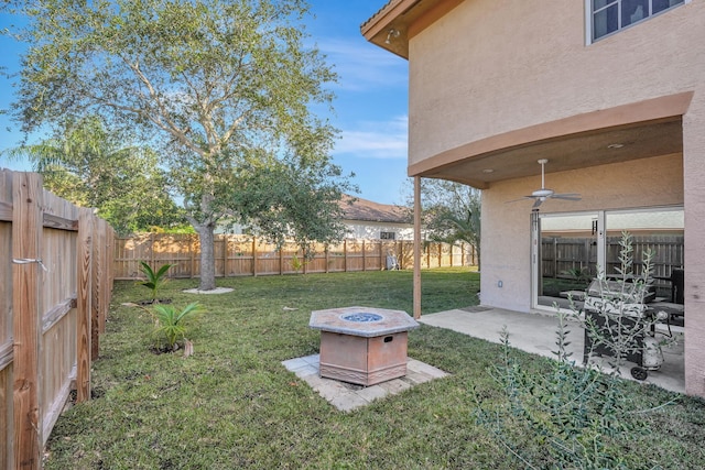 view of yard with a fire pit, a patio, a ceiling fan, and a fenced backyard