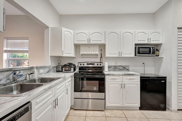 kitchen with a sink, white cabinets, light tile patterned floors, and stainless steel appliances