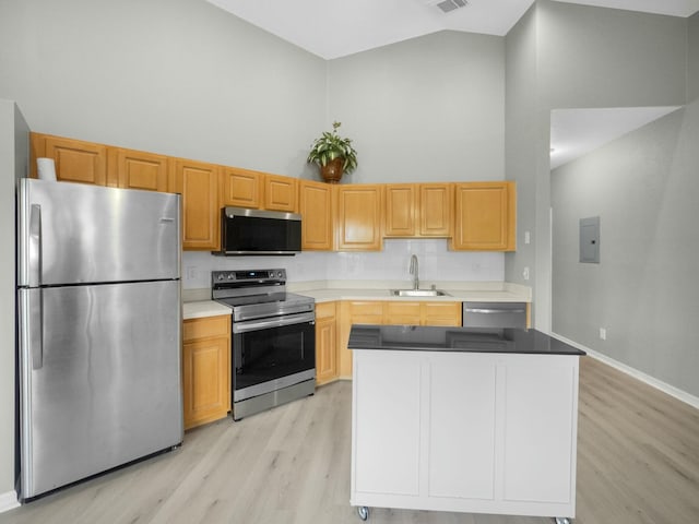 kitchen featuring appliances with stainless steel finishes, light hardwood / wood-style floors, high vaulted ceiling, and sink