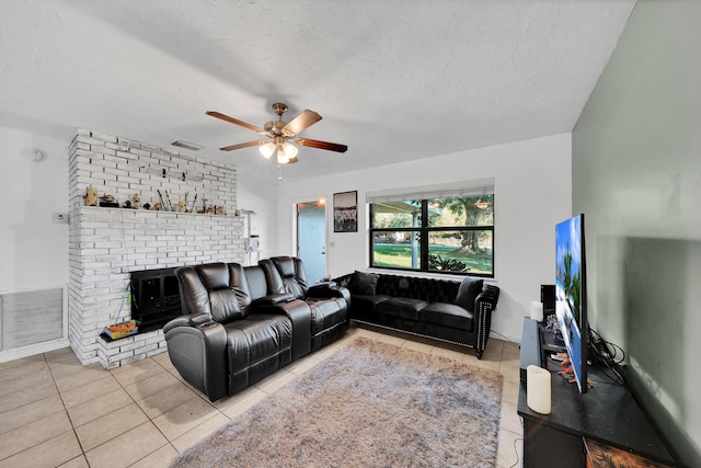 living room featuring light tile patterned floors, a textured ceiling, and ceiling fan