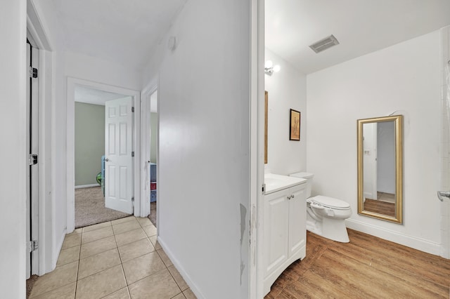 bathroom with a chandelier, vanity, hardwood / wood-style flooring, and toilet