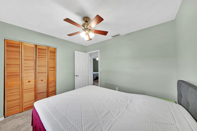 carpeted bedroom featuring ceiling fan and a closet