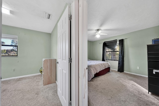 carpeted bedroom featuring ceiling fan and a textured ceiling