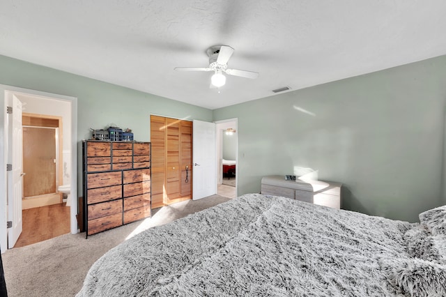 carpeted bedroom featuring ensuite bath, ceiling fan, a closet, and a textured ceiling