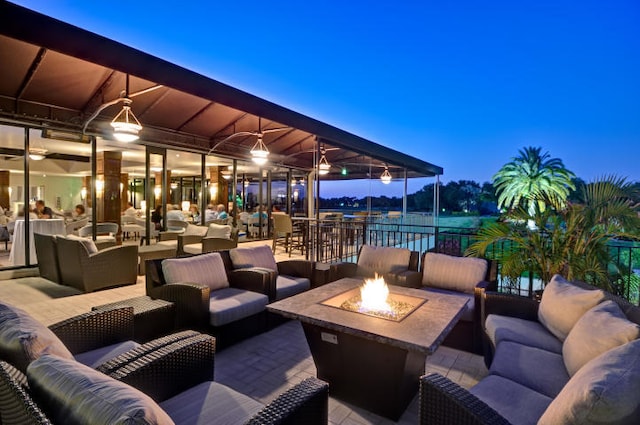 patio terrace at dusk with an outdoor living space with a fire pit