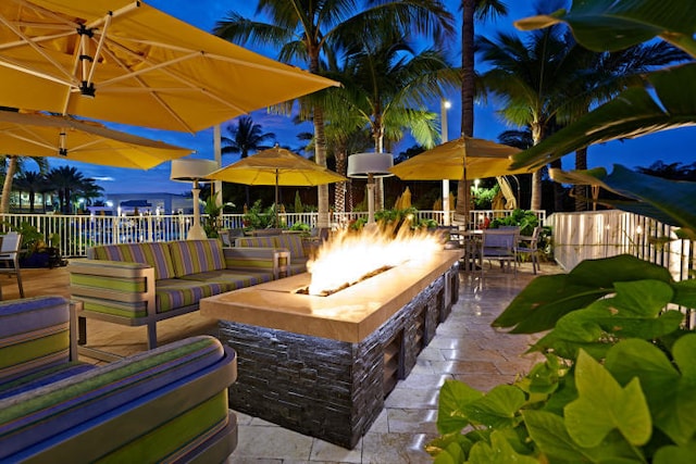 view of patio with an outdoor living space with a fire pit