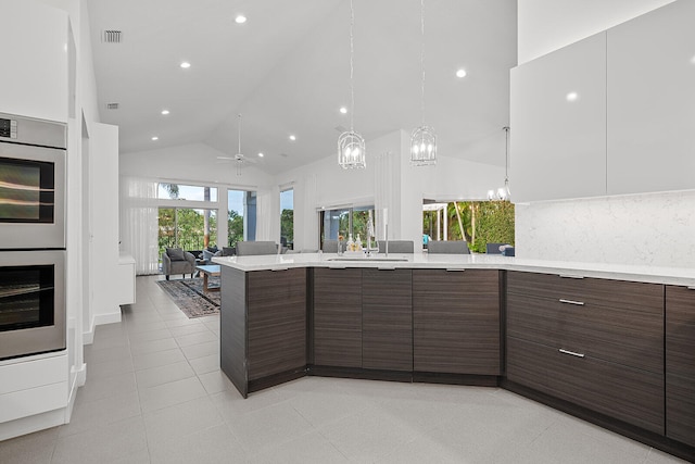 kitchen featuring high vaulted ceiling, ceiling fan, decorative backsplash, dark brown cabinets, and light tile patterned flooring