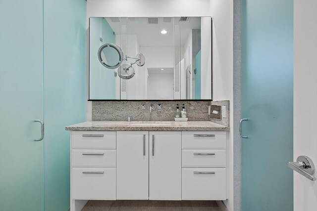 bathroom with vanity, tasteful backsplash, and an enclosed shower