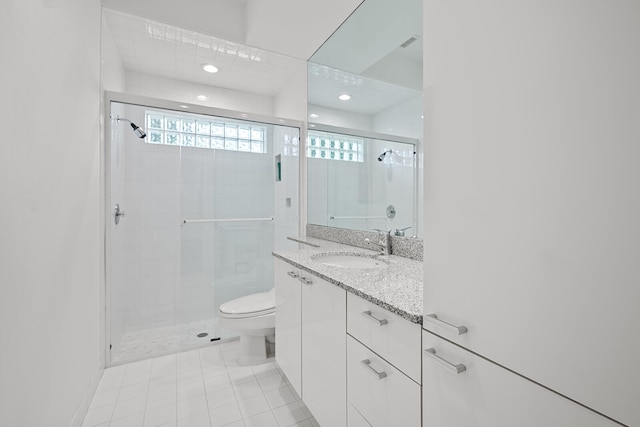 bathroom with tile patterned floors, vanity, toilet, and a shower with door