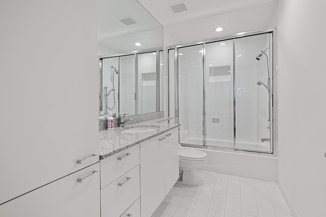 full bathroom featuring shower / bath combination with glass door, tile patterned flooring, vanity, and toilet