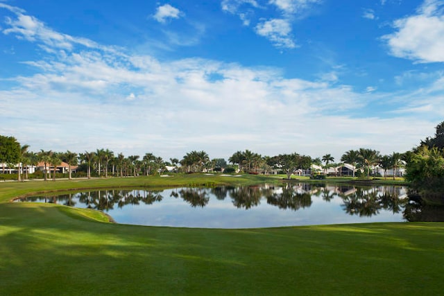 surrounding community with a water view and a lawn