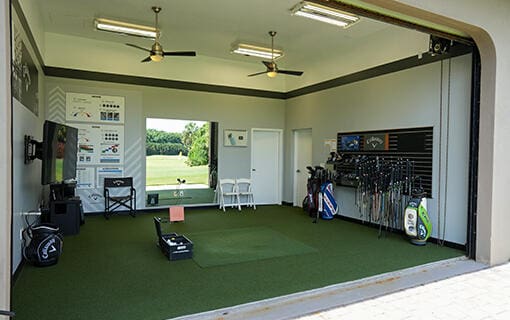 interior space with ceiling fan, golf simulator, and carpet floors