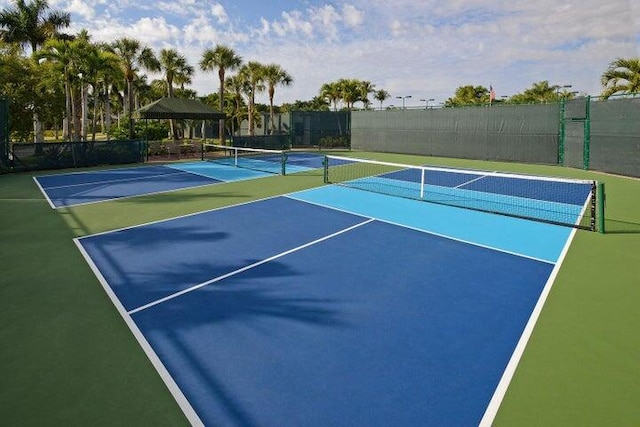 view of tennis court featuring a gazebo and basketball hoop