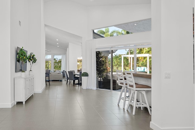 dining space featuring tile patterned floors, high vaulted ceiling, and plenty of natural light