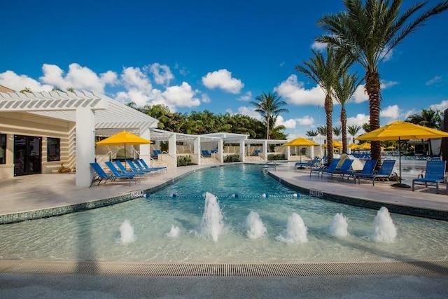 view of swimming pool with pool water feature, a pergola, and a patio