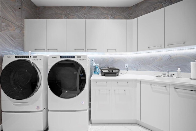 laundry room with washer and dryer, cabinets, and sink