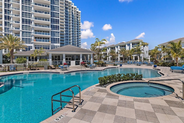 view of swimming pool with a patio area and a hot tub