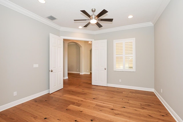 unfurnished room featuring hardwood / wood-style flooring, ceiling fan, and crown molding