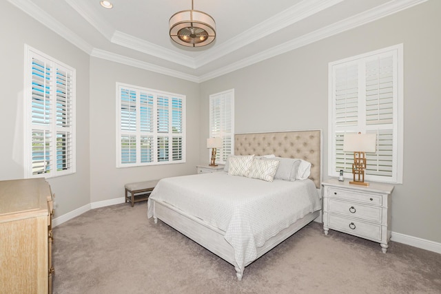 bedroom featuring light colored carpet, a tray ceiling, and ornamental molding