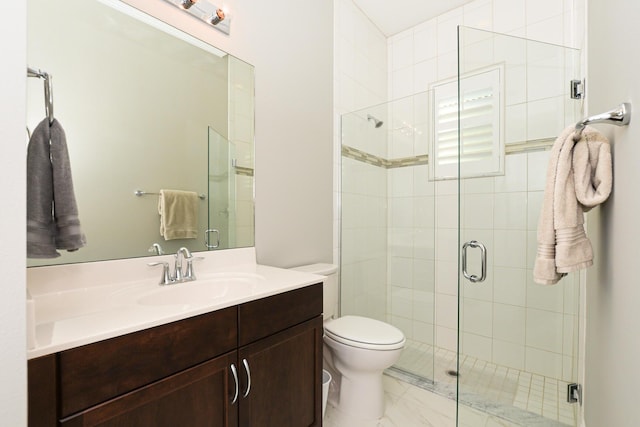 bathroom featuring vanity, toilet, and a shower with shower door