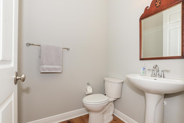 bathroom featuring wood-type flooring and toilet