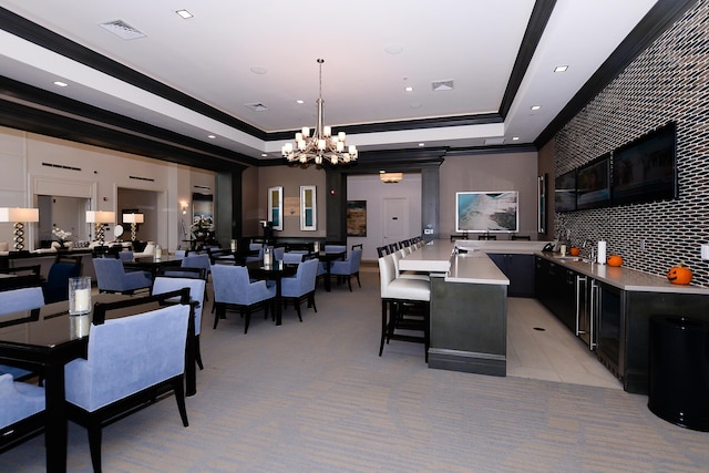 dining area featuring a chandelier, light colored carpet, a raised ceiling, and crown molding