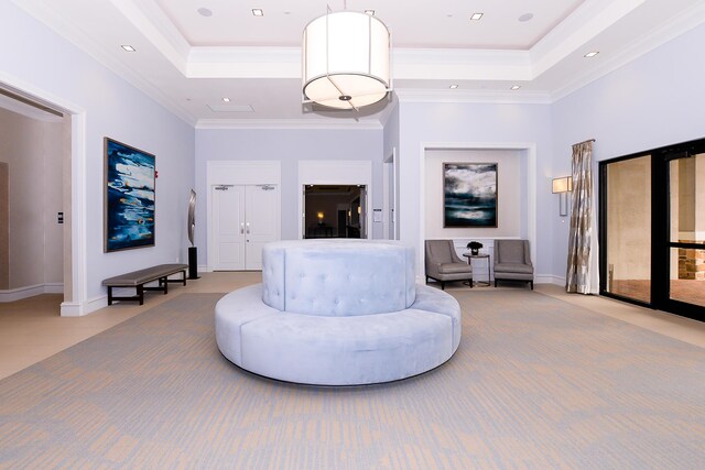 living area with a towering ceiling, crown molding, and a tray ceiling