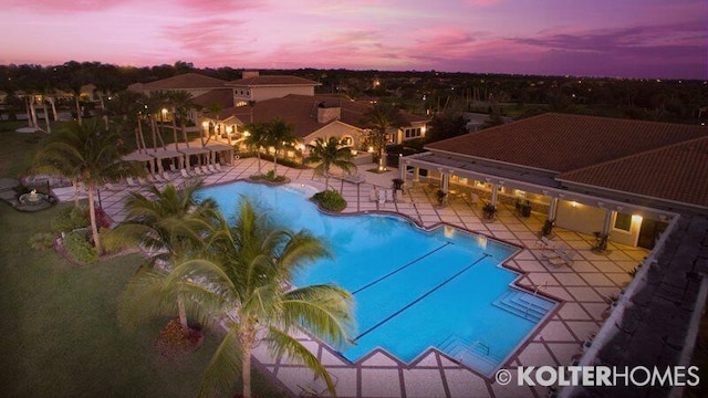 pool at dusk featuring a patio area