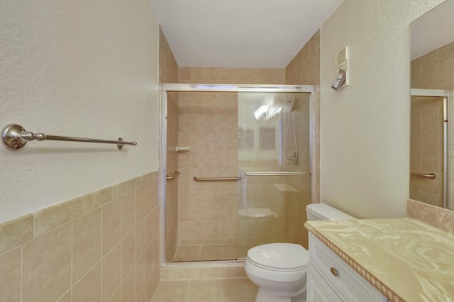 bathroom with tile patterned flooring, vanity, toilet, and an enclosed shower