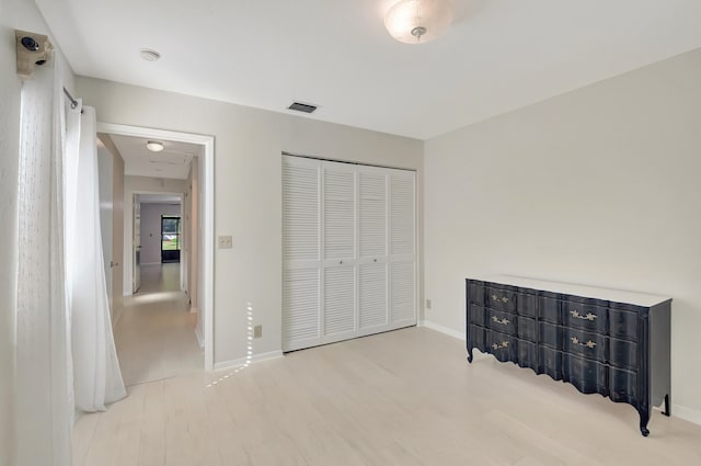 bedroom with light wood-type flooring and a closet