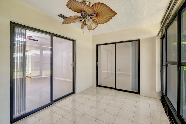 empty room featuring light tile patterned floors and ceiling fan