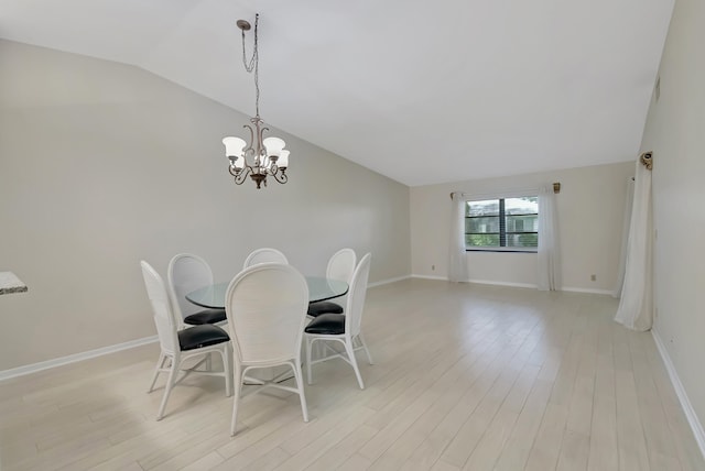 dining area featuring light wood-type flooring, lofted ceiling, and a chandelier