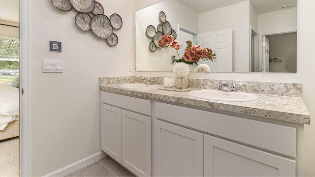ensuite bathroom with double vanity, a sink, visible vents, and ensuite bath