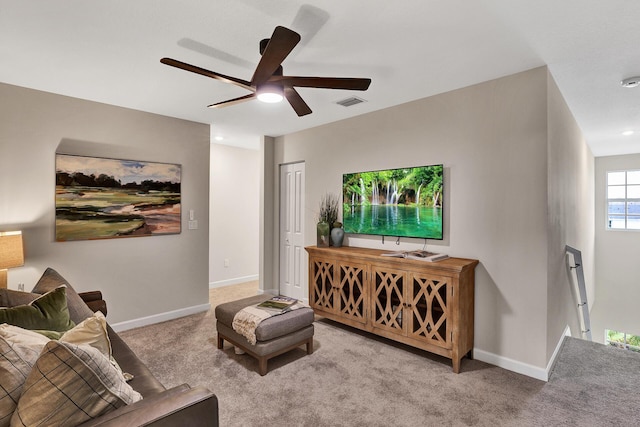 carpeted living area featuring ceiling fan, visible vents, and baseboards