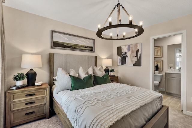 bedroom featuring lofted ceiling, light carpet, a notable chandelier, and ensuite bathroom