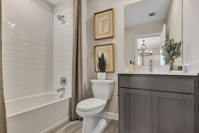 bathroom featuring toilet, vanity, baseboards, shower / bath combination with curtain, and an inviting chandelier