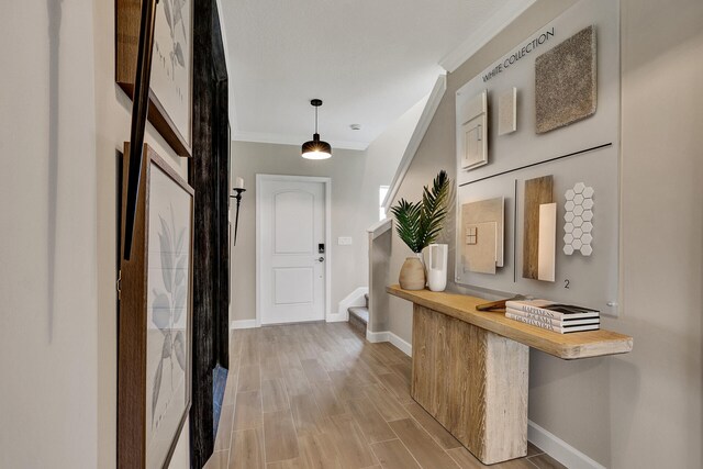 interior space with baseboards, ornamental molding, stairway, and wood tiled floor