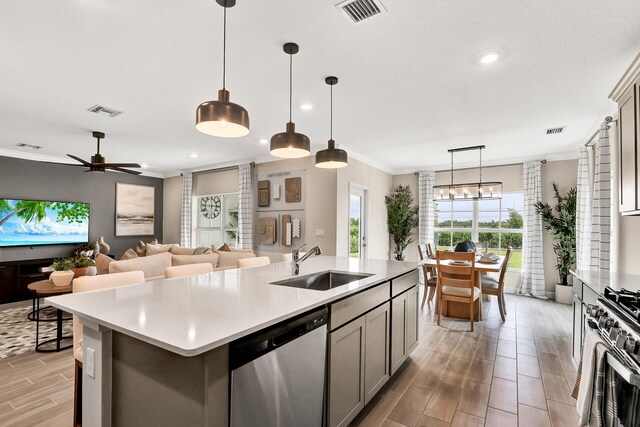 kitchen with visible vents, stainless steel appliances, a sink, and ornamental molding