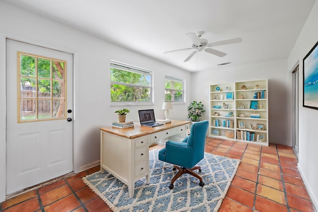 tiled home office featuring ceiling fan