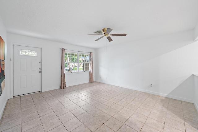 foyer entrance with ceiling fan and light tile patterned flooring