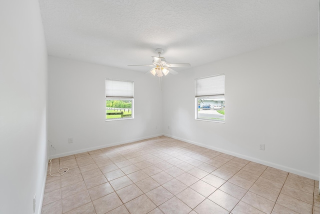 tiled empty room featuring ceiling fan and a textured ceiling