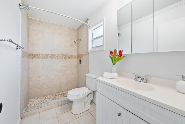 bathroom with a tile shower, vanity, crown molding, tile patterned flooring, and toilet