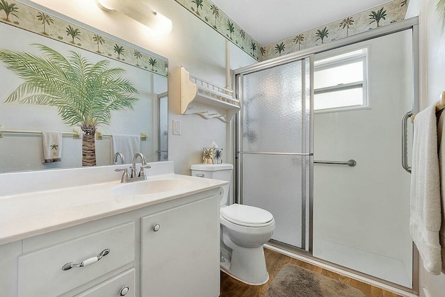 bathroom featuring hardwood / wood-style floors, vanity, toilet, and a shower with shower door