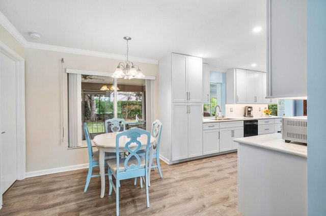 dining space with light hardwood / wood-style floors, sink, a wealth of natural light, and a chandelier