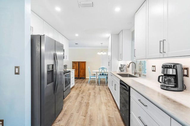 kitchen featuring white cabinetry, sink, stainless steel appliances, and light hardwood / wood-style flooring