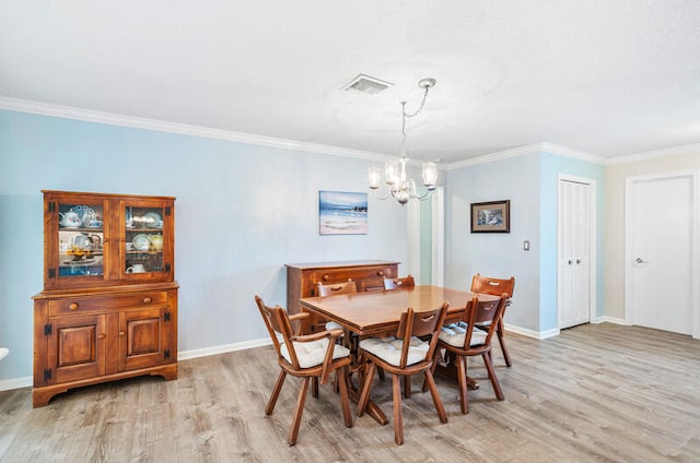 dining space featuring an inviting chandelier, light hardwood / wood-style flooring, and crown molding