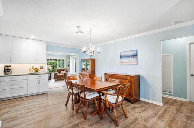 dining area with crown molding, a notable chandelier, and light wood-type flooring