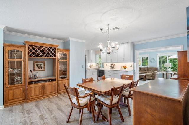 dining room featuring light hardwood / wood-style flooring, a chandelier, and ornamental molding